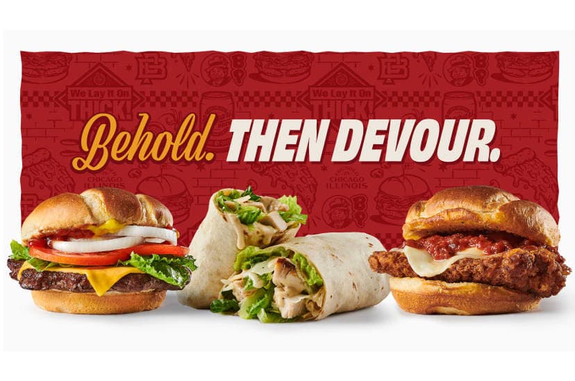 A burger, wrap, and chicken sandwich with a background of a red illustrated pattern and the headline “Behold. Then Devour.”