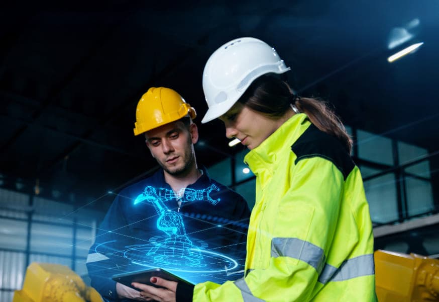 A male and female construction worker using a tablet with a digital hologram of a machine floating above the tablet.