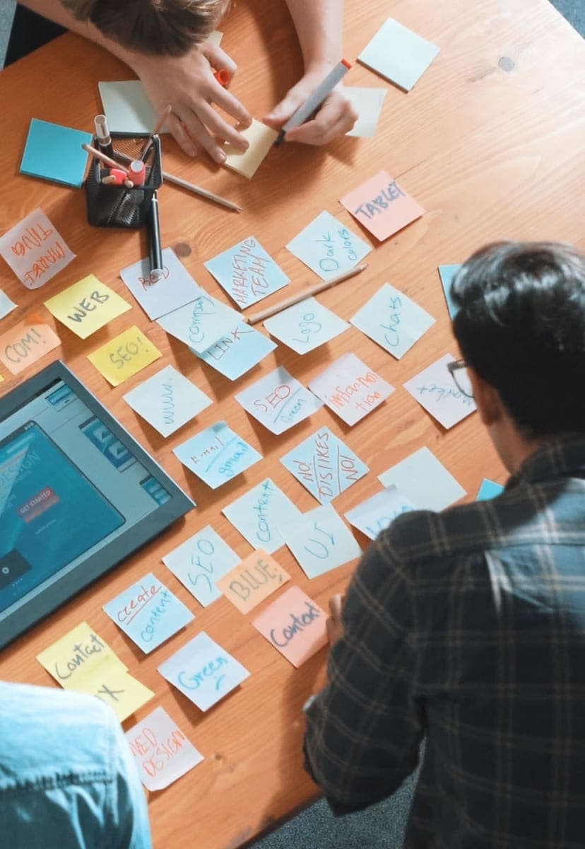 Group of people writing on and looking at sticky notes