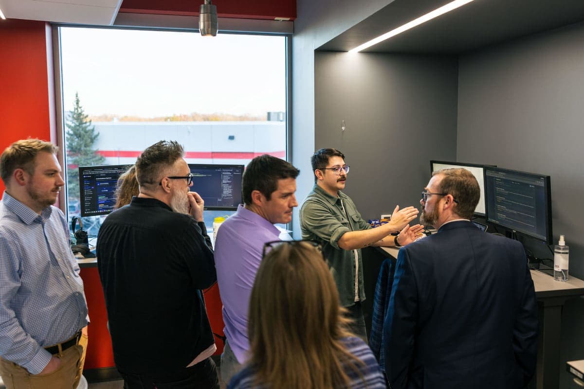 People standing around a computer screen