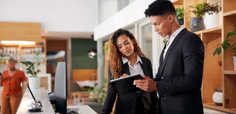 Two hotel workers collaborating together on an ipad