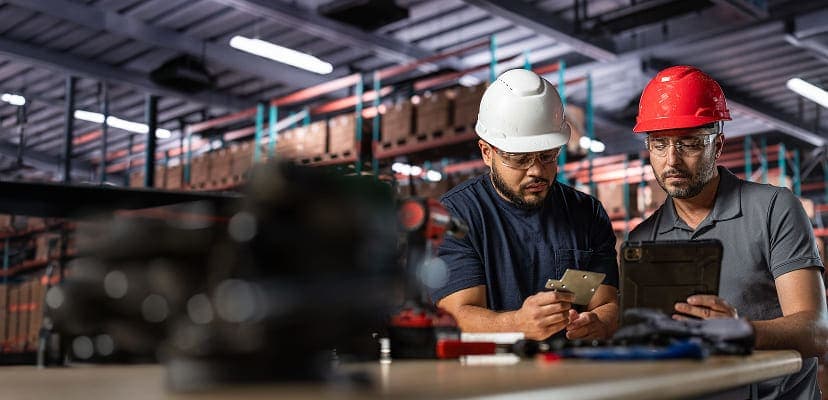 Two manufacturing workers collaborating on a tablet
