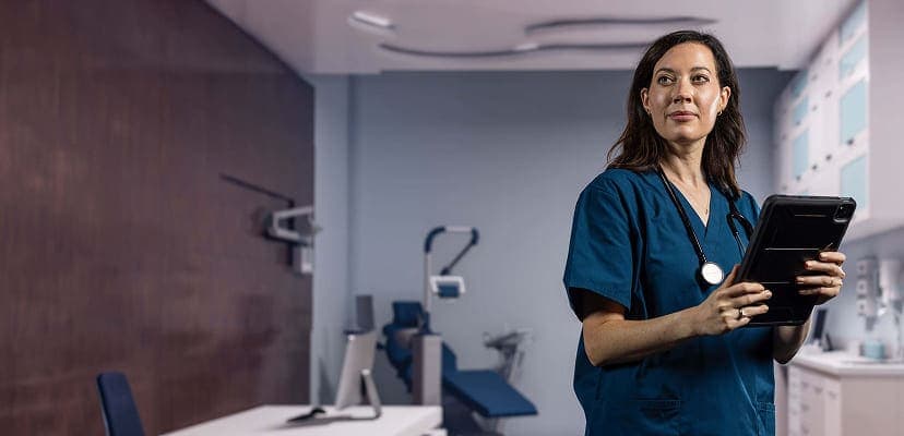 A female healthcare worker using a tablet in a prep room