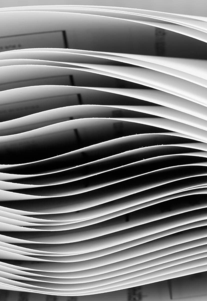 A side view of a stack of paper that has material freshly printed on it