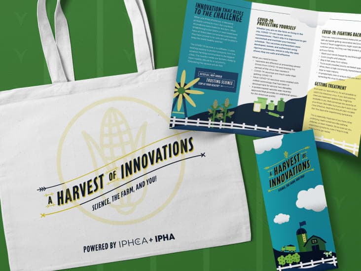 A white tote bag with the Harvest of Innovations logo on it beside informational brochures.