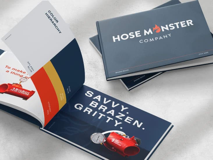 Two copies of the Hose Monster brand book, one is open.