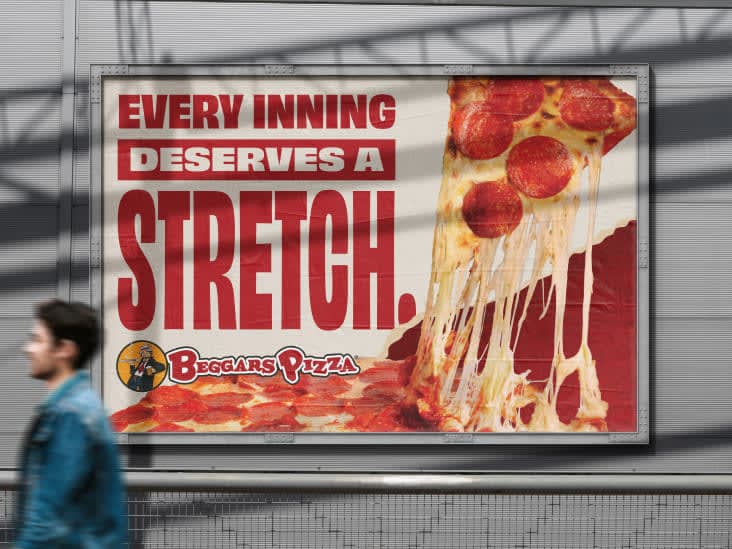 A billboard at Guaranteed Rate Field of a pepperoni slice lifting with a cheese pull and the headline “Every Inning Deserves a Stretch.”
