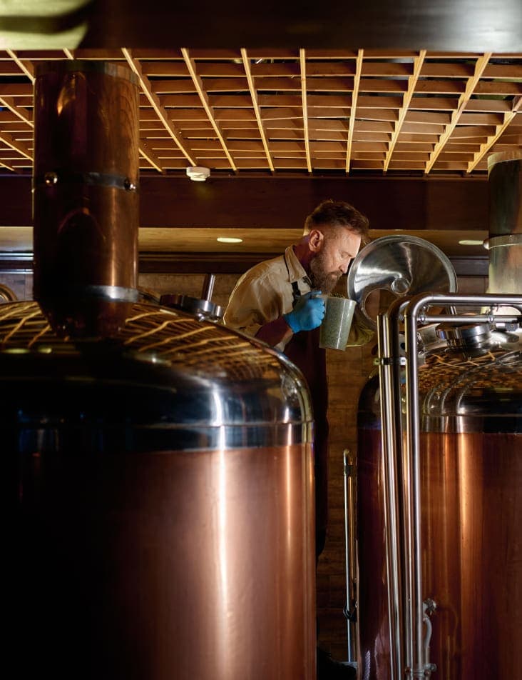 brewer man in room with many brewing machines