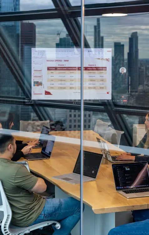 large team looking over data on a screen in a conference room
